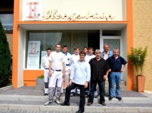 Gruppe von Personen, die vor einem Gebäude mit dem Schriftzug 'Hengsbach' stehen.